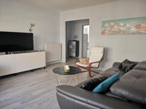 - un salon avec un canapé et une télévision dans l'établissement Tout le charme de La Baule-Les -Pins T3 73m2, à La Baule