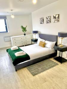 ein Schlafzimmer mit einem großen Bett mit zwei Nachttischen in der Unterkunft Amazing 1 bedroom flat with balcony views to the city 19th floor in Manchester