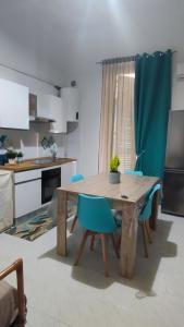 cocina con mesa de madera y sillas azules en Dimora Dante 310, en Bari