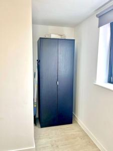 eine blaue Tür in der Ecke eines Zimmers in der Unterkunft Amazing 1 bedroom flat with balcony views to the city 19th floor in Manchester