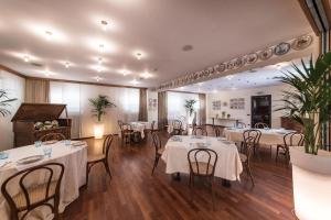 um restaurante com mesas e cadeiras e um piano em Manuelina Taste Hotel em Recco