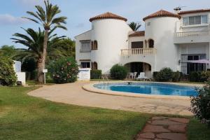 a house with a swimming pool in front of it at Playa del Sol-Casa Playa in Denia