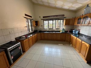 a large kitchen with wooden cabinets and a stove at Beautiful home opposite Speke Resort Munyonyo near Lake Victoria in Kampala