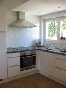 a white kitchen with a stove and a window at Blue House Rügen in Altenkirchen