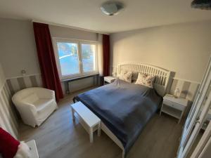 1 dormitorio pequeño con 1 cama y 1 silla en Harzgenuß, en Braunlage