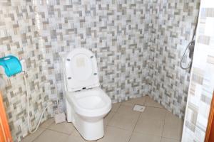 a bathroom with a toilet in a tiled wall at POAPARK RESORT 