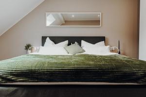 um quarto com uma cama grande e um cobertor verde em WohnungTraveller Geislautern em Völklingen