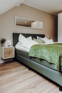 ein Schlafzimmer mit einem großen Bett und einer grünen Decke in der Unterkunft WohnungTraveller Geislautern in Völklingen