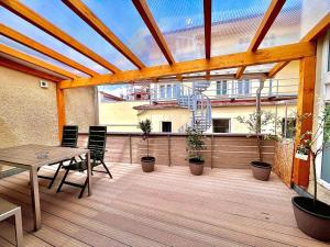 un patio con mesa y sillas en una terraza de madera en Bavaria City Hostel - Design Hostel en Füssen