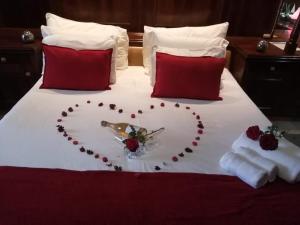 uma cama em forma de coração com um coração feito de rosas em Makhadzi's clouds lodge em Dalmada