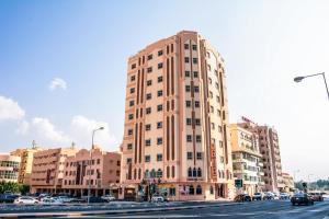 un edificio alto al lado de una calle de la ciudad en Al Misrea Tower, en Juffair