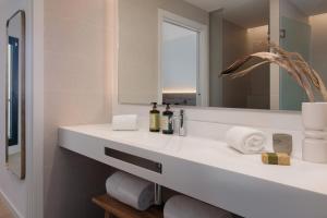 bagno con lavandino bianco e specchio di Tembo Barcelona a Barcellona