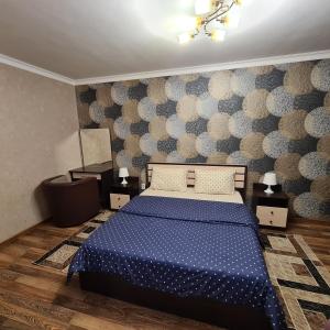 um quarto com uma cama com um edredão azul em Квартира посуточно в центре г.Петропавловска em Petropavl