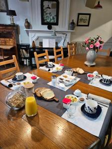 stół ze śniadaniem i sokiem pomarańczowym w obiekcie LA GARDE DUCALE w mieście Moncontour