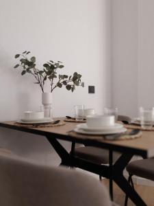 a wooden table with plates and a potted plant on it at Tembo Barcelona in Barcelona