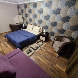 1 dormitorio con 1 cama y 1 sofá en Квартира посуточно в центре г.Петропавловска en Petropavlovsk