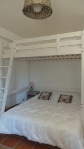 - une chambre avec des lits superposés blancs et une échelle dans l'établissement Jolie Maison avec jardin et piscine privée, à Sablet