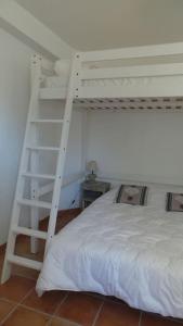 um quarto com um beliche branco e uma escada em Jolie Maison avec jardin et piscine privée em Sablet