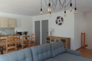 uma sala de estar com um sofá azul e uma sala de jantar em Jolie Maison avec jardin et piscine privée em Sablet