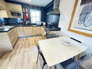 a kitchen with a white table and chairs at Casa Crusoe - Part of the The Bay Filey Holiday Village with pool, gym and direct beach access, pub, restaurant, tennis and meadows walks in Reighton