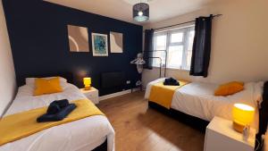 een slaapkamer met 2 bedden en gele en zwarte muren bij Stunning Cosy 2 Bedroom Flat with Parking, Central in Birmingham