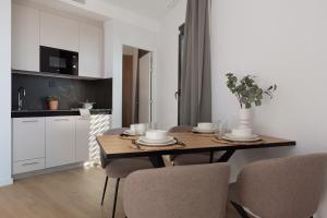 uma mesa de jantar com cadeiras e uma cozinha em Tembo Barcelona em Barcelona
