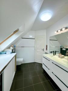 ein Badezimmer mit zwei Waschbecken, einem WC und einem Spiegel in der Unterkunft Maison lumineuse à Torcy in Torcy