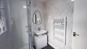 een badkamer met een wastafel, een spiegel en een douche bij Stunning Cosy 2 Bedroom Flat with Parking, Central in Birmingham