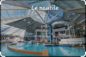 a large swimming pool in a large building at Appartement hyper centre, cathédrale, fibre in Lisieux