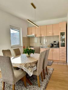 a kitchen with a dining room table and chairs at Apartmani Andric in Trebinje
