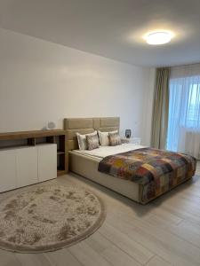 a bedroom with a large bed and a rug at Central apartment Panoramic View in Iaşi