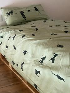 uma cama com pássaros pretos num edredão branco em Casa Capricho em Horcajo de las Torres