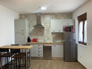 uma cozinha com electrodomésticos brancos e uma mesa de madeira em Casa Capricho em Horcajo de las Torres