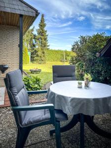 une table avec deux chaises et une table avec un tissu de table blanc dans l'établissement Gemütliches Nest mit Garten in der Heide, 