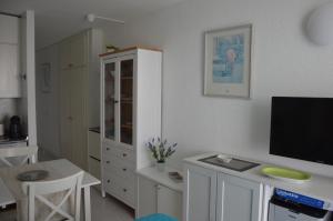 a kitchen with a tv and a white cabinet at Studio Ponderosa in Playa de las Americas