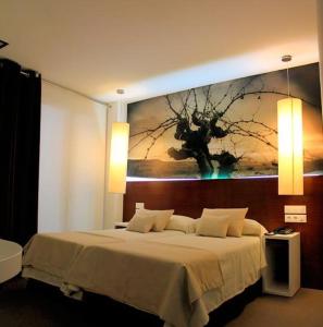 La SolanaにあるHotel La Casotaのベッドルーム1室(壁に絵画が描かれたベッド1台付)