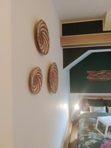 Maya sweet rooms في هيرلين: غرفة نوم مع قبعتين معلقتين على الحائط