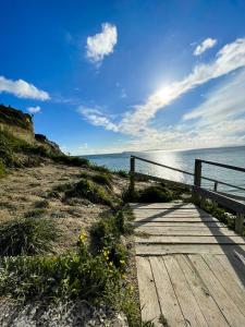 a wooden pathway leading to the ocean on a beach at Villa Elia in Peroulades