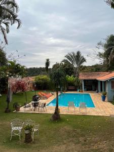 uma piscina com mesa e cadeiras num quintal em Casulo da mamys em Itu