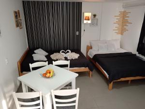 a room with two beds and a table with a bowl of fruit at Smestaj Stanisavljevic in Soko Banja