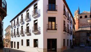 Un gran edificio blanco con balcones en una calle. en Hotel La Casota, en La Solana
