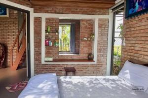 um quarto com uma cama numa parede de tijolos em Homestay Mộc Nhi em Hue