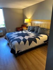 a bedroom with a bed with a blue and white blanket at Madison Inn & Suites in Madison