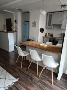 a kitchen with white chairs and a kitchen counter at Cocon familial proche de Paris in Issy-les-Moulineaux