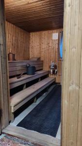 a wooden sauna with benches and a pot at Huoneisto Ilomantsin Kivilahdessa in Kivilahti