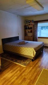 a bedroom with a bed and a wooden floor at Huoneisto Ilomantsin Kivilahdessa in Kivilahti