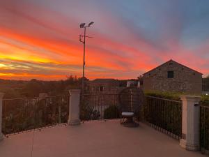 a chair sitting on a balcony with a sunset at Masseria Cisternella in Alliste