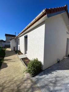 un edificio blanco con una entrada al lado en Maison cosy avec jardin calme, en Savigny-sur-Orge