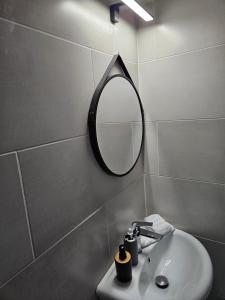 een badkamer met een spiegel en een wastafel bij Rigas stone tower east Mani 1 in Mína