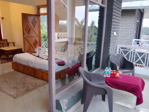 a room with a bed and a table and chairs at The Farmerian Resort in Belparāo